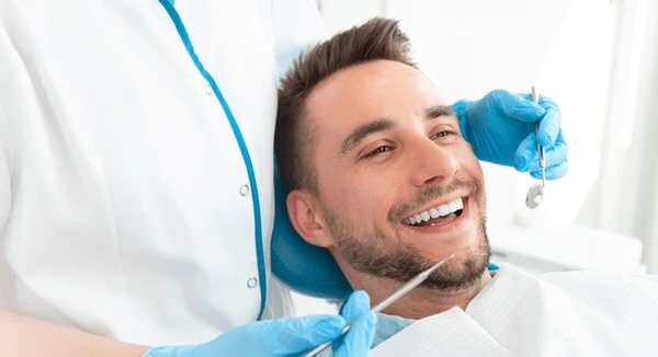 man smiling while dentist works 600nw 2434905873